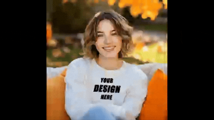 Editable Sweatshirt Mockup- a girl sitting in a couch with pillows beside her with a background of falls season