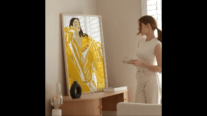 Wall Art Frame Mockup Template with Lively a girl sipping coffee- a girl drinking coffee while looking at a frame with a canvas of a girl and sun