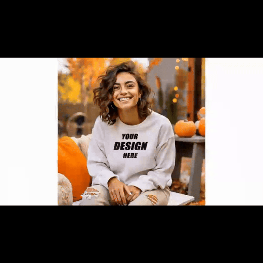 White Sweatshirt Mockup Design- a girl sitting and smiling wearing sweatshirt and a background of pumpkin on the side of the table
